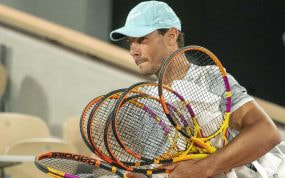 Rafael Nadal entra a la pista central de Roland Garros con sus raquetas para un entrenamiento en 2022.