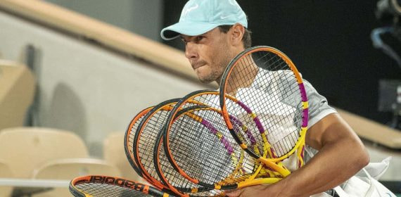 Rafael Nadal entra a la pista central de Roland Garros con sus raquetas para un entrenamiento en 2022.