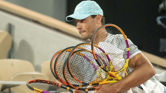 Rafael Nadal entra a la pista central de Roland Garros con sus raquetas para un entrenamiento en 2022.