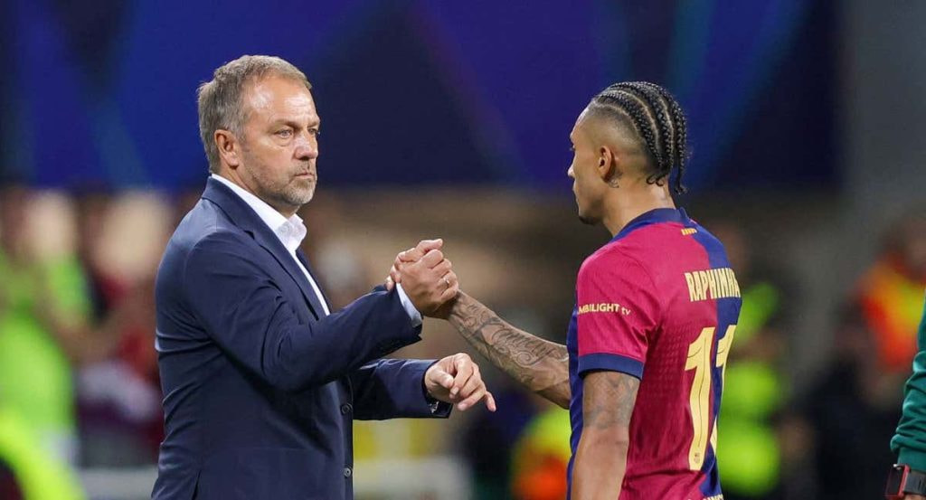 Hansi Flick, durante un momento del partido en el banquillo, con Raphinha.