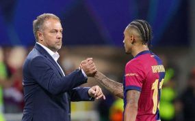 Hansi Flick, durante un momento del partido en el banquillo, con Raphinha.