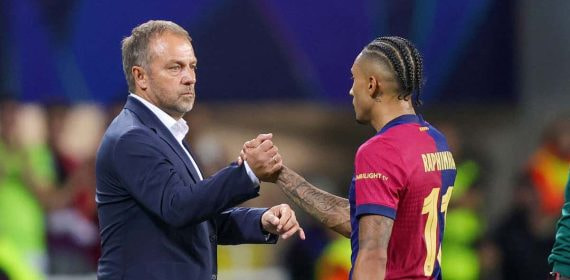 Hansi Flick, durante un momento del partido en el banquillo, con Raphinha.