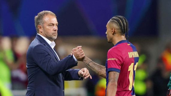 Hansi Flick, durante un momento del partido en el banquillo, con Raphinha.