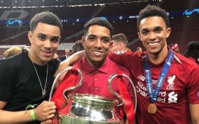 Marcel, Tyler y Trent Alexander-Arnold posan con la Champions que consiguió el Liverpool en 2019 en el Metropolitano.