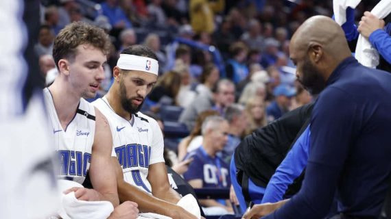 Jugadores de Orlando Magic reciben instrucciones de su entrenador en un tiempo muerto de un partido de la NBA.
