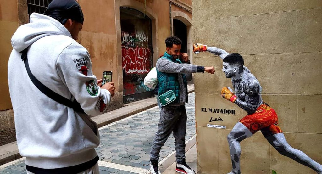 Unos paseantes se fotografían con el mural de Ilia Topuria en el barrio de Born, en Barcelona.