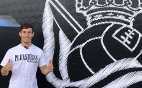 Aihen Muñoz, posando feliz junto al escudo de la Real en las instalaciones de Zubieta.