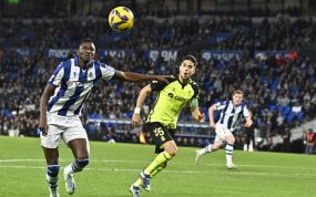 Sadiq se dispone a rematar un balón ante la atenta mirada de Bartra en un Real Sociedad-Betis.