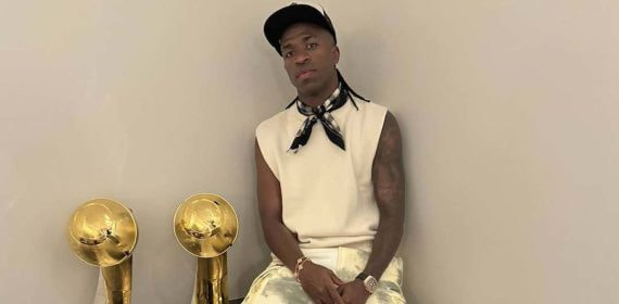 Vinicius, posando con dos premios en su casa.