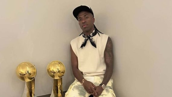 Vinicius, posando con dos premios en su casa.