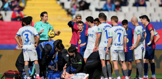 Los jugadores, tendidos en el suelo junto a sus compañeros en el transcurso del encuentro.