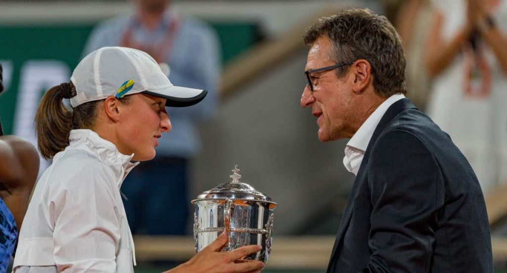 Iga Swiatek, suspendida un mes por dopaje, recibe la copa de Roland Garros 2022 de manos de Mats Wilander.