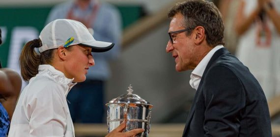 Iga Swiatek, suspendida un mes por dopaje, recibe la copa de Roland Garros 2022 de manos de Mats Wilander.