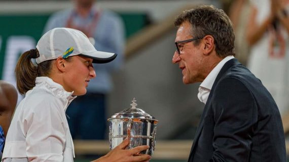 Iga Swiatek, suspendida un mes por dopaje, recibe la copa de Roland Garros 2022 de manos de Mats Wilander.