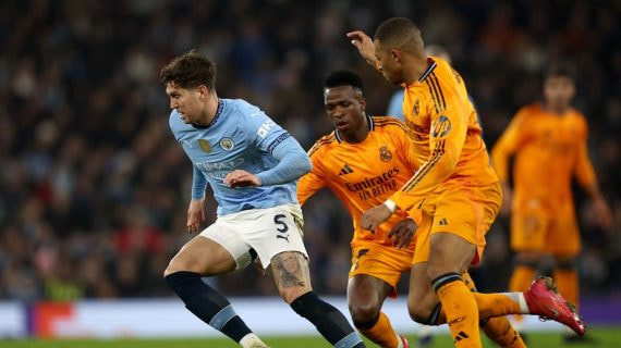 Vinicius y Mbappé persiguen a Stones para robarle un balón.