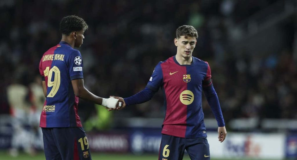 Lamine Yamal le da la mano a Gavi durante el Barça-Benfica.