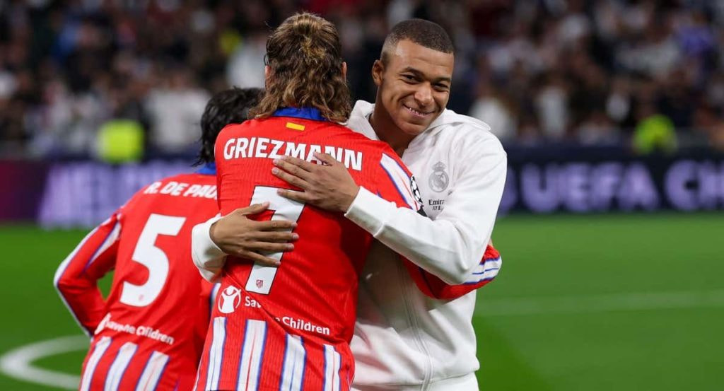 Griezmann y Mbappé se saludan antes de un derbi.