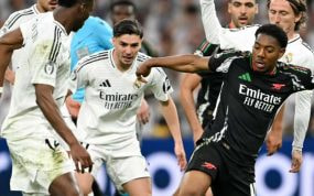 Lewis-Skelly controla un balón entre los futbolistas del Real Madrid.