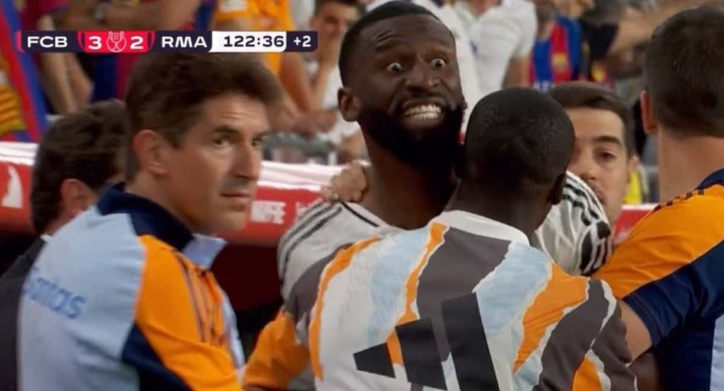 Varias personas del Real Madrid sujetan a Rüdiger.