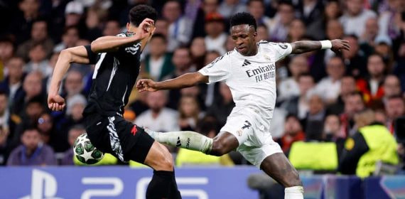 Vinicius intenta marcharse de Saliba en el Bernabéu.