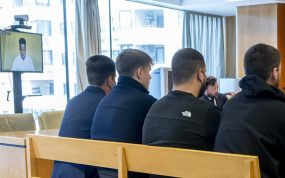 Los radicales del Atlético acusados con Vinicius testificando de fondo.