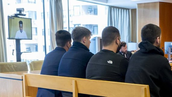 Los radicales del Atlético acusados con Vinicius testificando de fondo.
