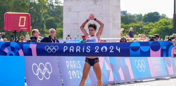 María Pérez cruzando la meta en el relevo mixto de marcha en los Juegos de París 2024.