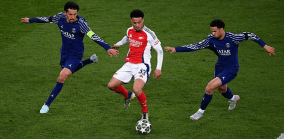 Un jugador del Arsenal regatea entre dos rivales del Paris Saint-Germain