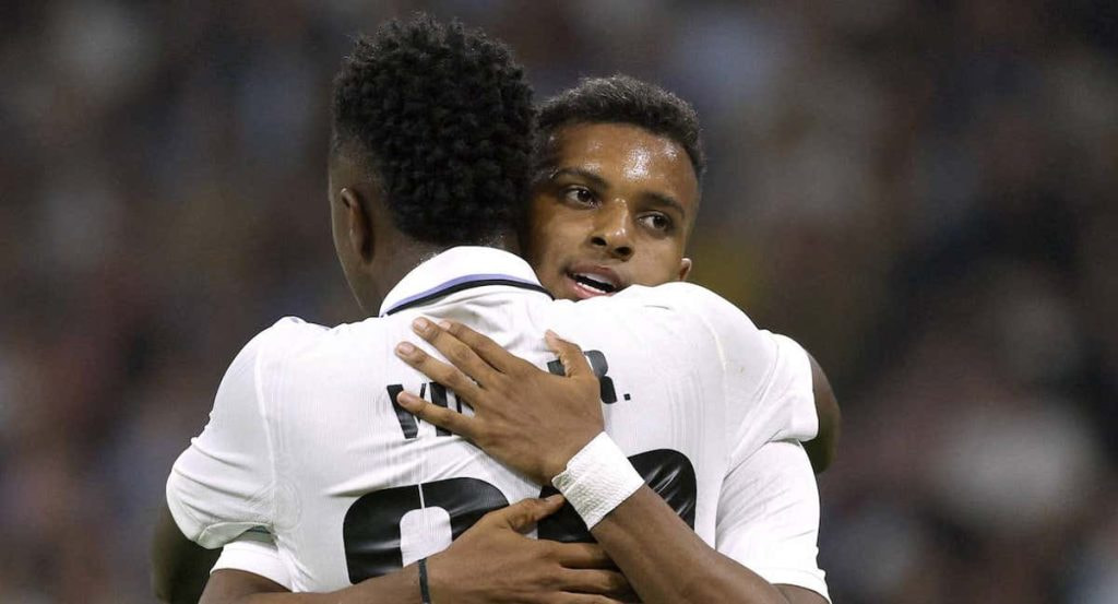 Vinicius y Rodrygo celebrando abrazándose durante un partido.