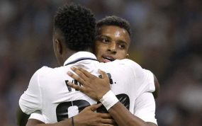 Vinicius y Rodrygo celebrando abrazándose durante un partido.