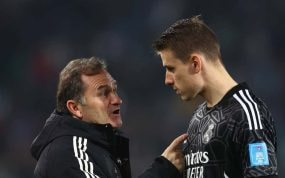 Llopis y Lunin hablan antes de un partido del Real Madrid.