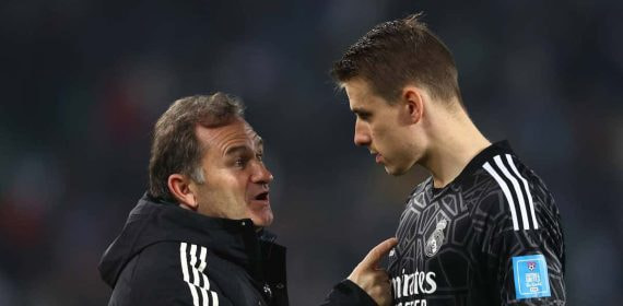Llopis y Lunin hablan antes de un partido del Real Madrid.