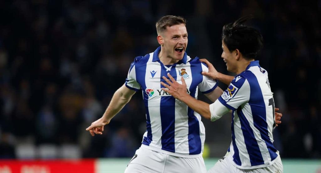 Sergio Gómez celebra un gol junto a Take Kubo con la Real Sociedad.