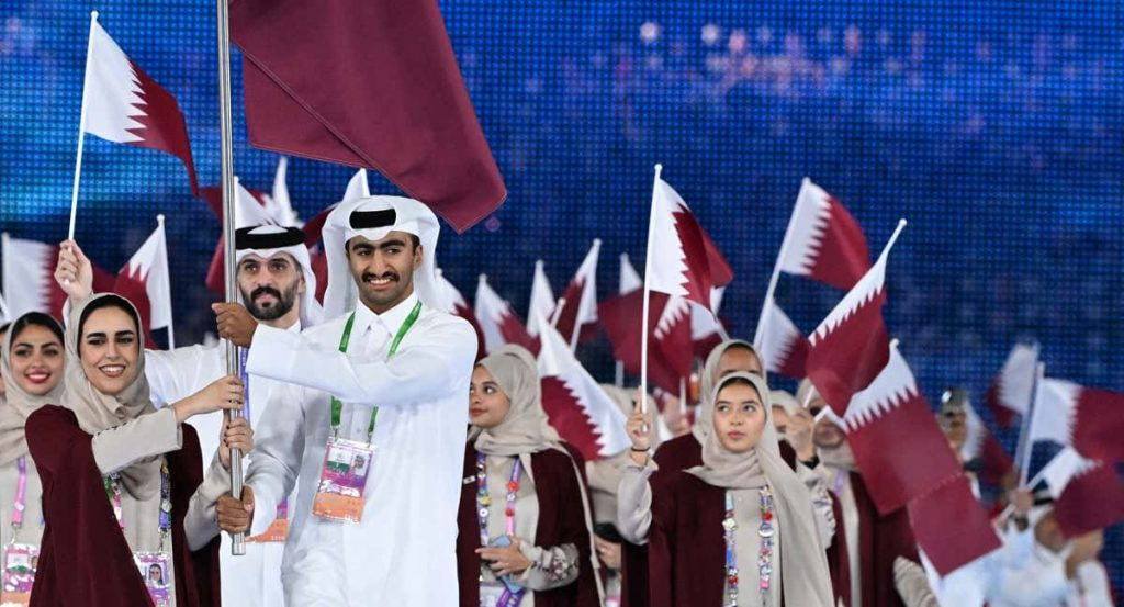 La delegación de Catar desfila con banderas en una ceremonia inaugural