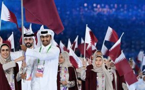 La delegación de Catar desfila con banderas en una ceremonia inaugural