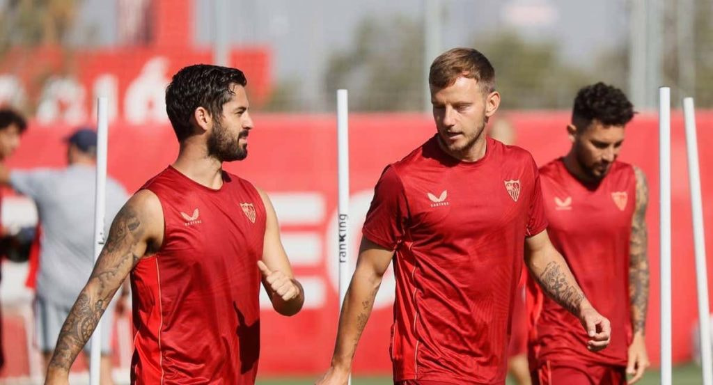Isco charla con Rakitic en un entrenamiento del Sevilla.