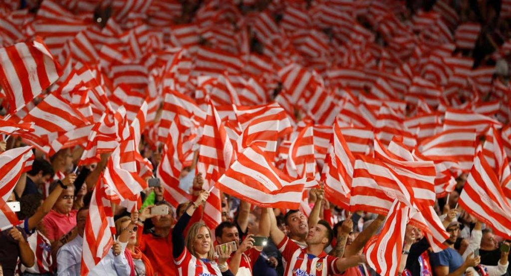 La afición del Atlético de Madrid canta el himno.
