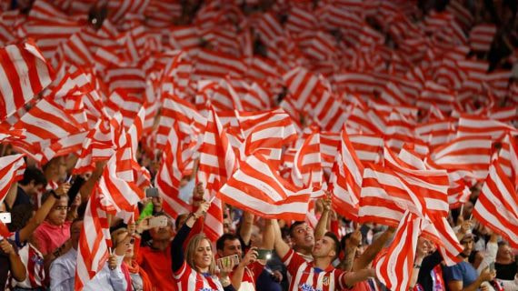 La afición del Atlético de Madrid canta el himno.