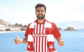 Vicente Iborra posa con la camiseta y la bufanda del Olympiacos junto al mar