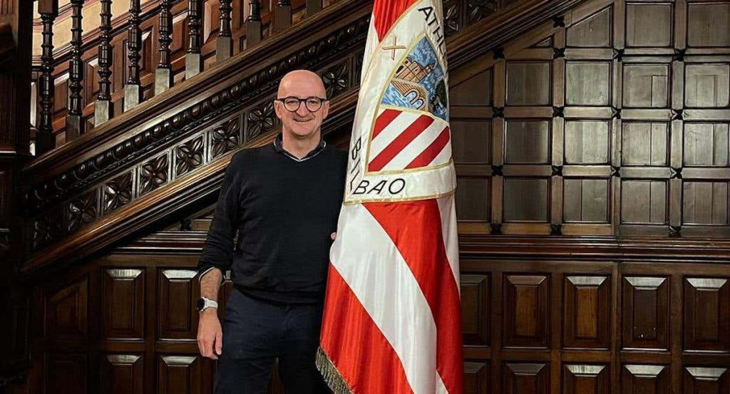 Iñigo San Millán posa junto a la bandera del Athletic de Bilbao en la sede del club.
