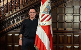 Iñigo San Millán posa junto a la bandera del Athletic de Bilbao en la sede del club.