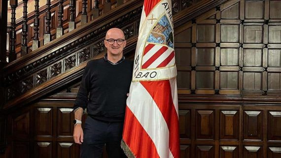 Iñigo San Millán posa junto a la bandera del Athletic de Bilbao en la sede del club.