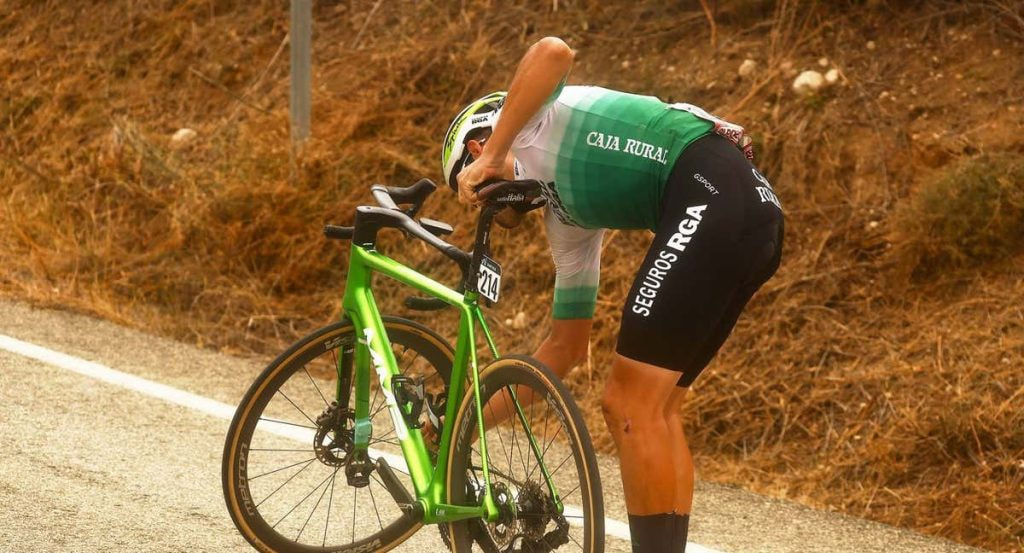 Un ciclista de Caja Rural-Seguros RGA repara una avería durante La Vuelta.