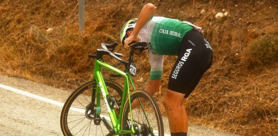 Un ciclista de Caja Rural-Seguros RGA repara una avería durante La Vuelta.