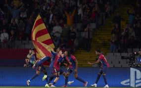 Los jugadores del FC Barcelona celebran un gol con sus aficionados de fondo.