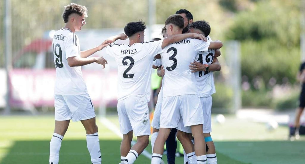 Los jugadores del juvenil de Real Madrid se abrazan en la banda.