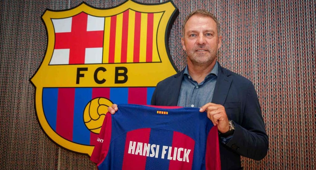 Hansi Flick posando con la camiseta del FC Barcelona el día de la firma.