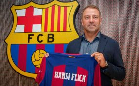 Hansi Flick posando con la camiseta del FC Barcelona el día de la firma.