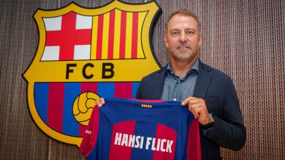 Hansi Flick posando con la camiseta del FC Barcelona el día de la firma.