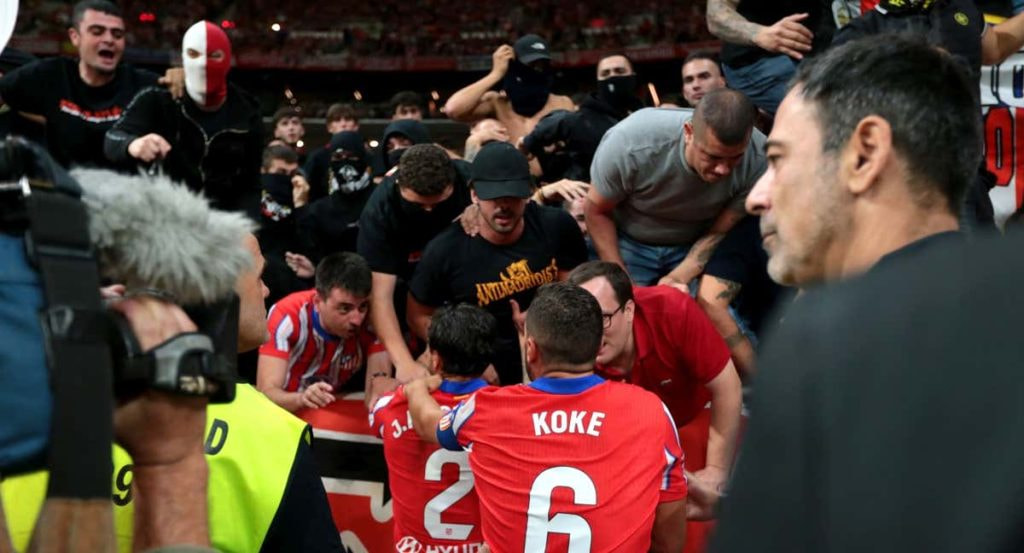 Giménez y Koke dialogan con los ultras del Metropolitano tras los lanzamientos de objetos a Courtois.